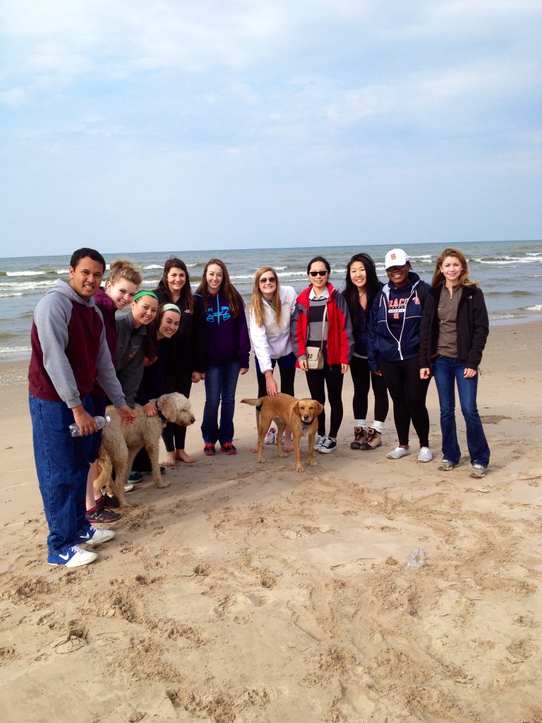 students pose on the beach with John Western