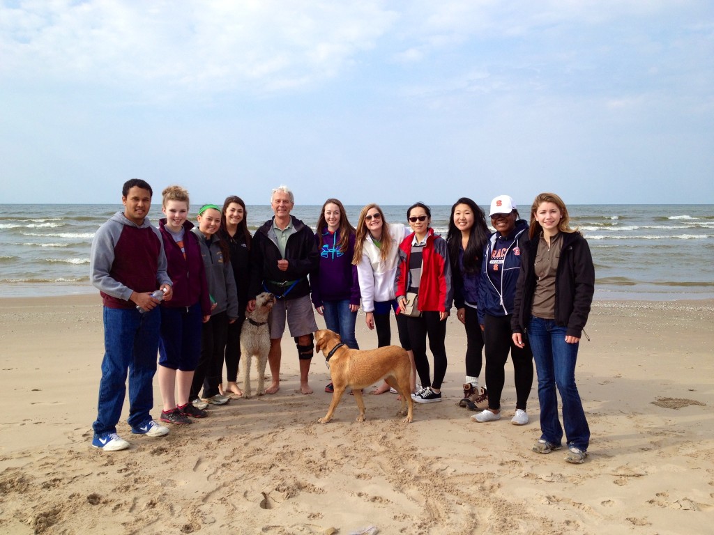 students pose on beach with John Western